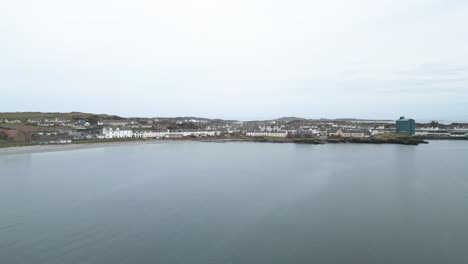 Aerial-towards-Port-Ellen,-Islay-located-on-the-shore-with-the-sea