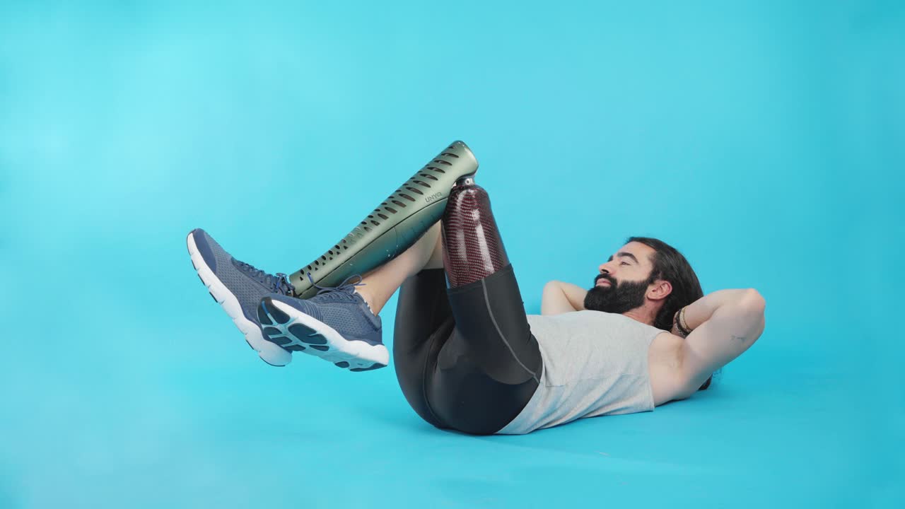 Uomo con protesi alle gambe che fa esercizi addominali.