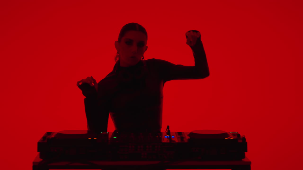 una mujer tocando en un estudio iluminado en rojo.