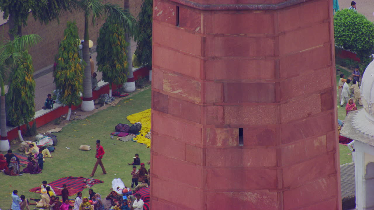 la comunidad sikh se sentó y descansó en el parque del templo, una vista de cerca de los minaretes del templo