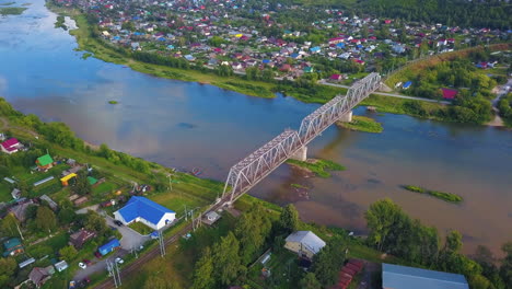 vista aérea del río y el puente ferroviario sobre una pequeña ciudad