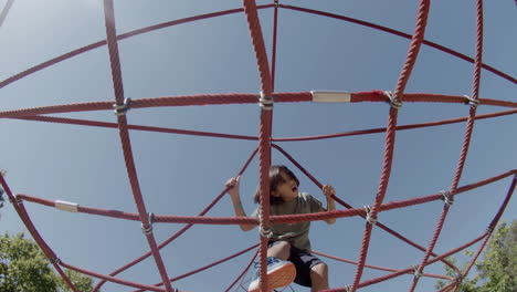 Niño-Enfocado-Haciendo-Ejercicio-En-La-Atracción-De-Cuerdas-En-El-Parque-De-Verano