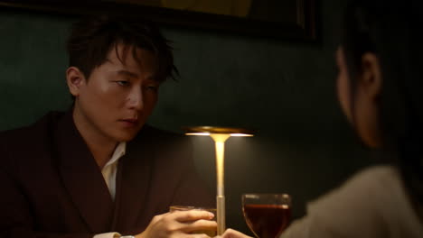 a tense moment between an asian couple, sitting in silence during a breakup