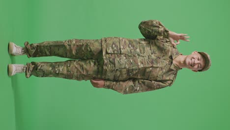 full body of asian man soldier smiling and showing okay gesture to camera while standing in the green screen background studio