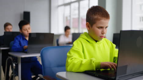 children using laptops in a computer classroom