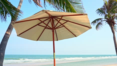 una sombrilla de lona ofrece sombra en una playa tropical