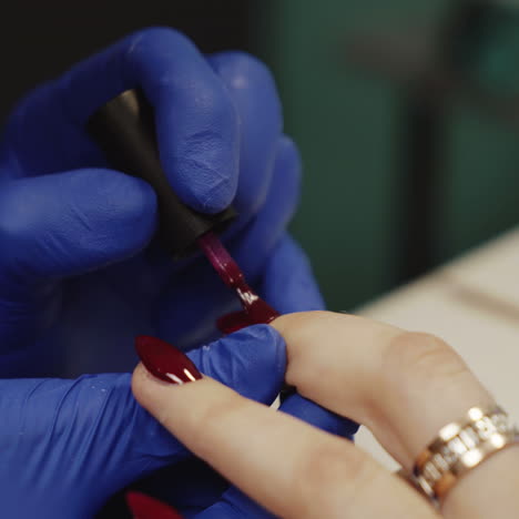 una mujer se pinta las uñas.