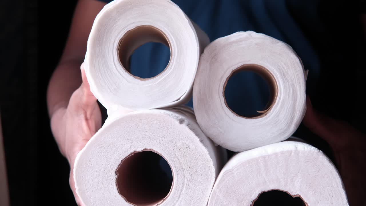 Hands holding rolls of toilet paper