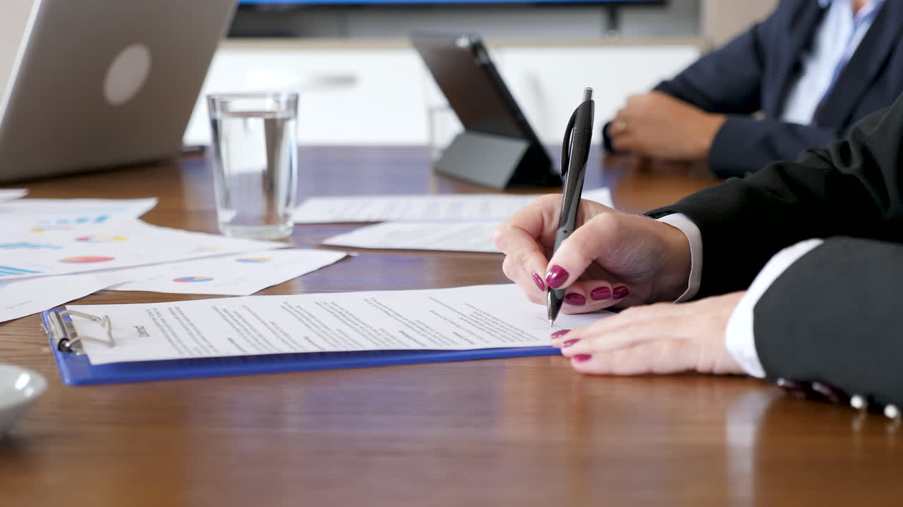 Business meeting with contract signing and paperwork
