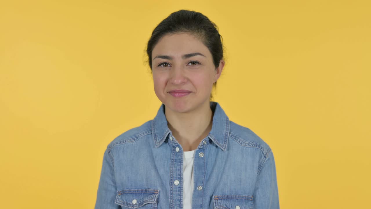 joven india somnolienta bostezando, fondo amarillo