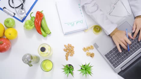 Healthy-foods-and-dietitian-working-with-laptop-at-table.