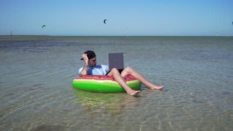 a young business person is enthusiastically working behind a laptop swaying on the waves of sea