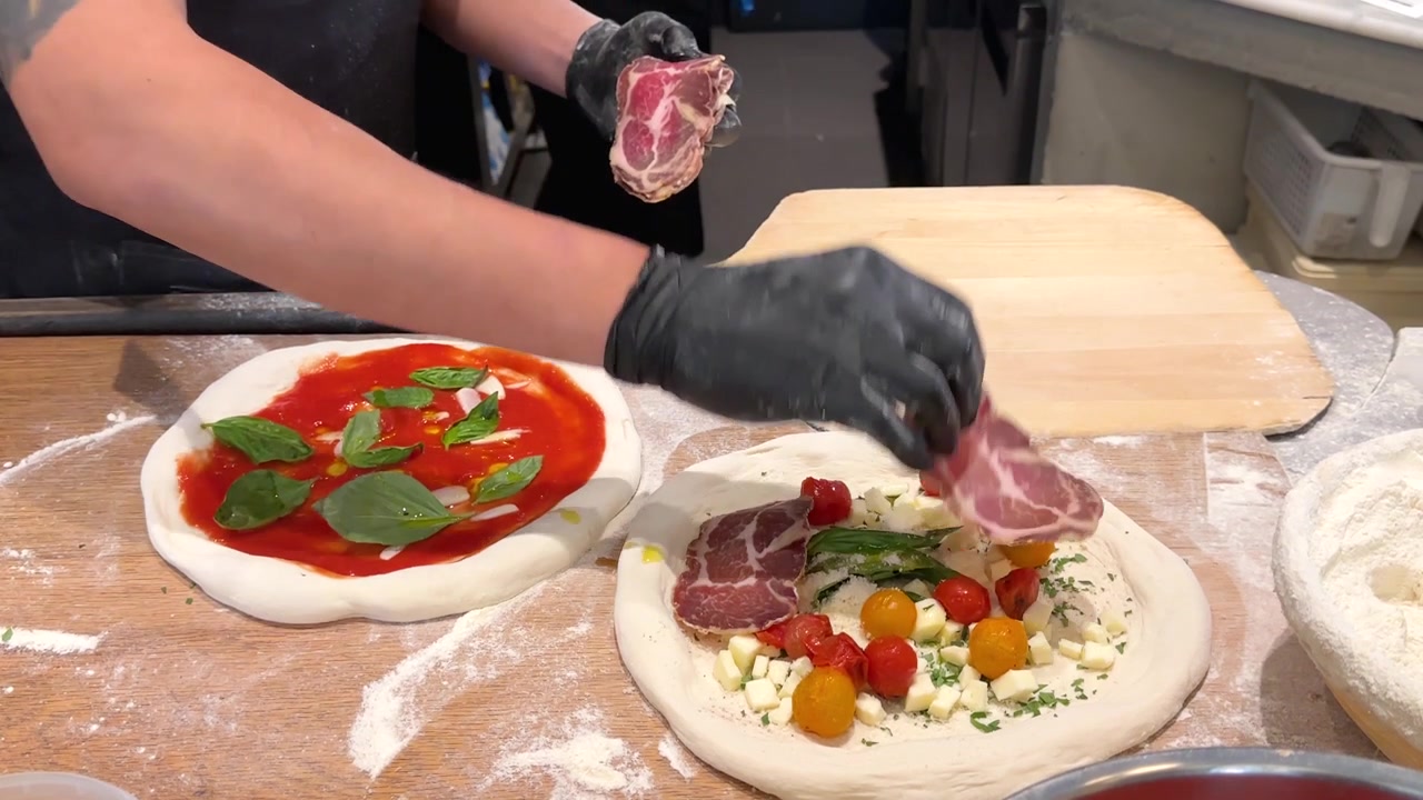 Chef che prepara pizza gourmet con salumi e verdure fresche