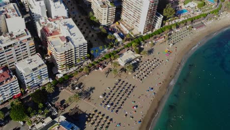 Drone-footage-from-a-beach-by-the-promenade-in-Marbella,-Spain