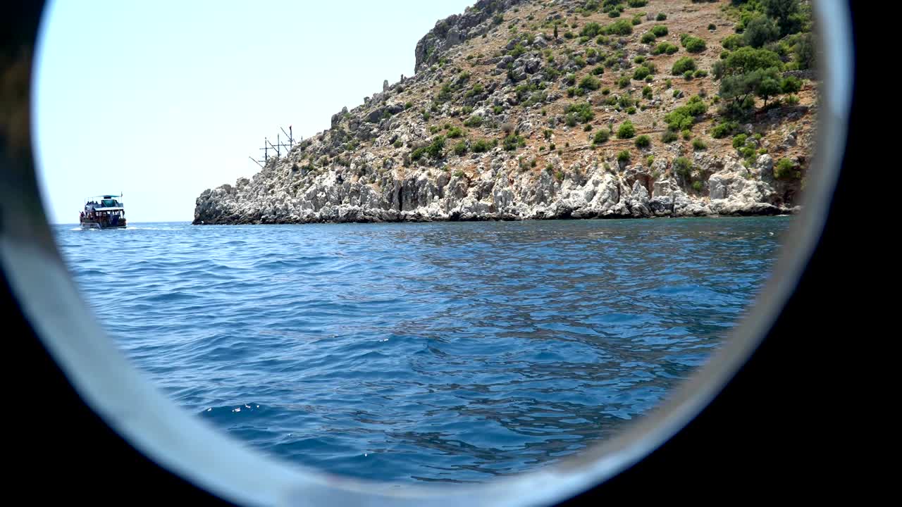 배경에 있는 배들, 바위가 있는 해안