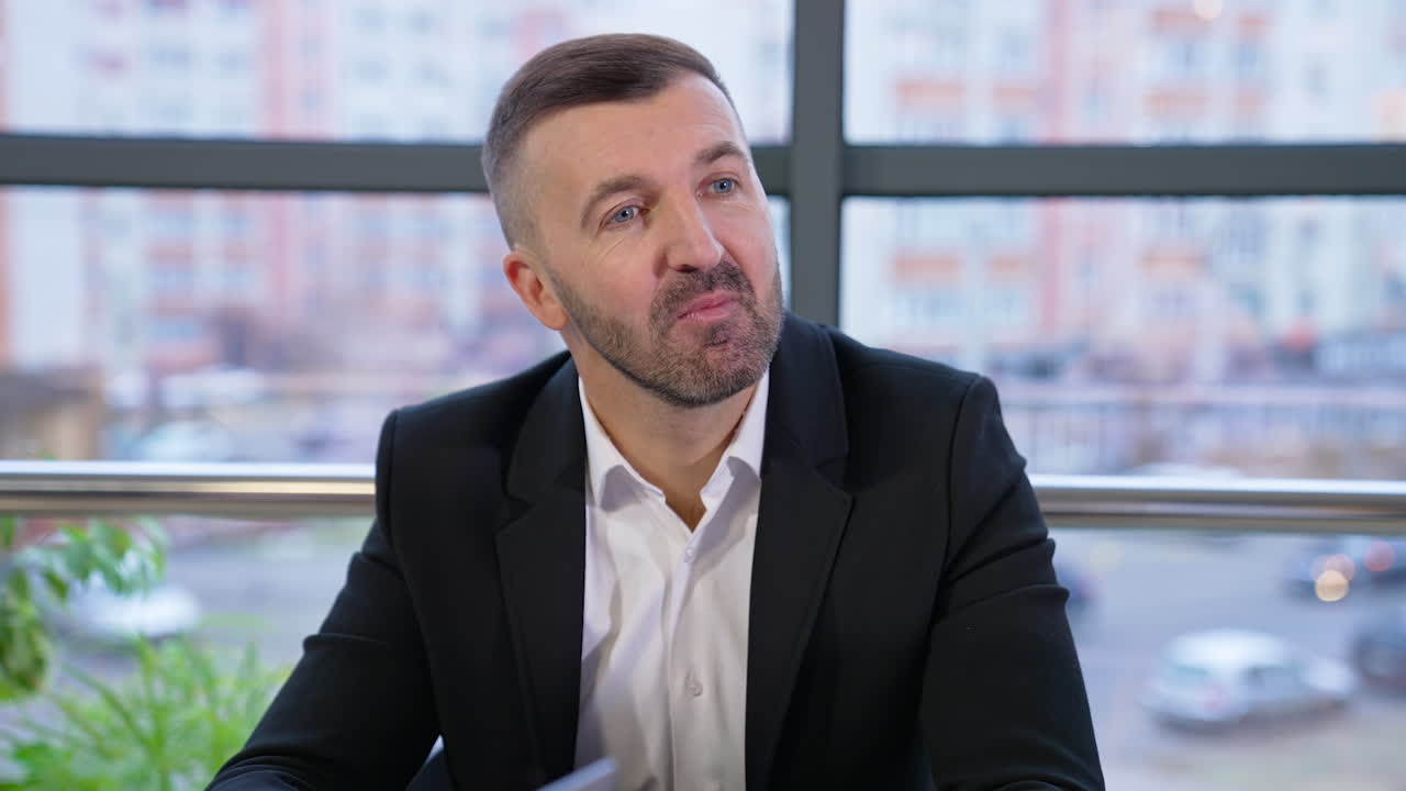 Mid-aged good-looking businessman talks to his employees listening to their ideas. Young long-haired female office worker responding to her boss.