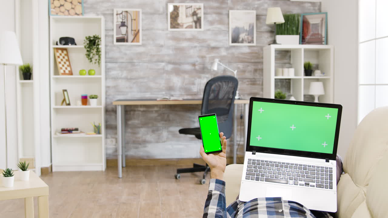 persona que utiliza una computadora portátil y un teléfono inteligente en el hogar