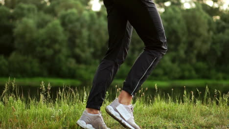 a girl in a pink jacket is preparing for a run warm up and listen to music in headphones through the phone