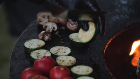 chef preparing delicious grilled food on open fire grill in the backyard for the quests during summer evening