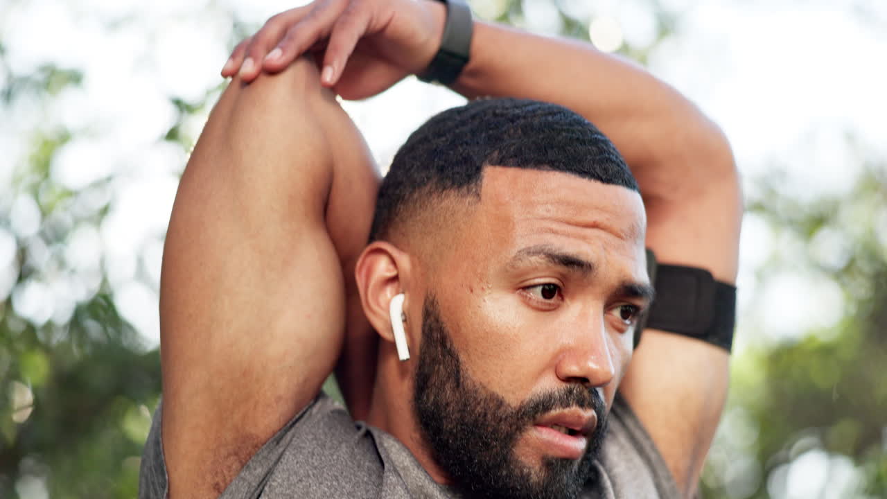 hombre, estirando los brazos y corriendo en el parque