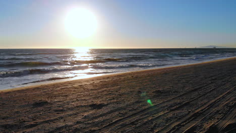 Vuelo-Rápido-Por-La-Torre-De-Salvavidas-Hacia-Las-Olas-Del-Océano-Y-La-Hermosa-Puesta-De-Sol-Con-Un-Dron-Aéreo-De-4k-En-La-Playa-De-Huntington,-En-El-Sur-De-California