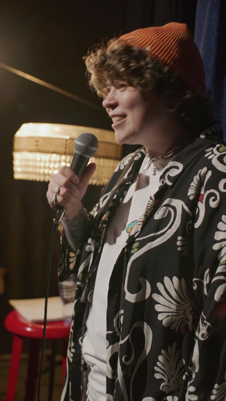 Comica sorridente che si esibisce in un monologo di stand-up sul palco