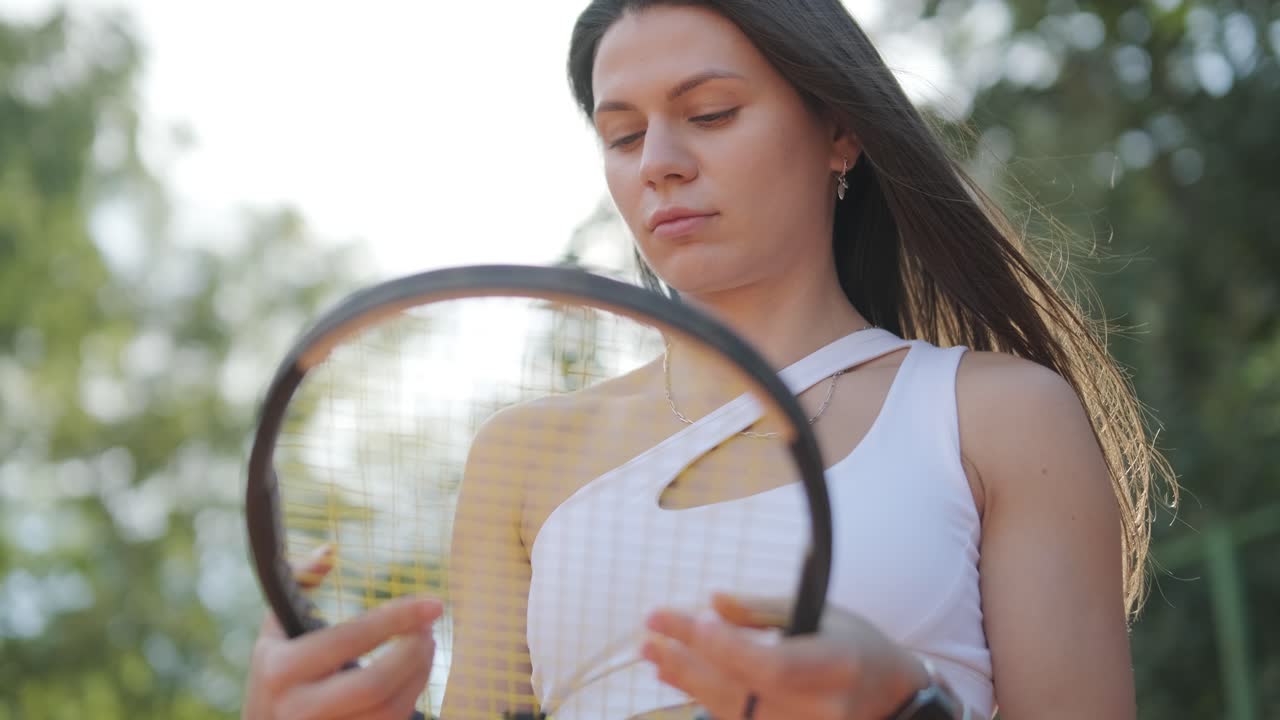 una mujer joven practicando tenis en una cancha al aire libre con un entrenador. el entrenador proporciona orientación a medida que la jugadora trabaja en su técnica, perfeccionando sus golpes en una sesión de entrenamiento atlético.