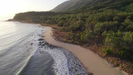 wellen plätschern in der abenddämmerung an der felsigen küste von wangetti beach im norden von queensland, australien