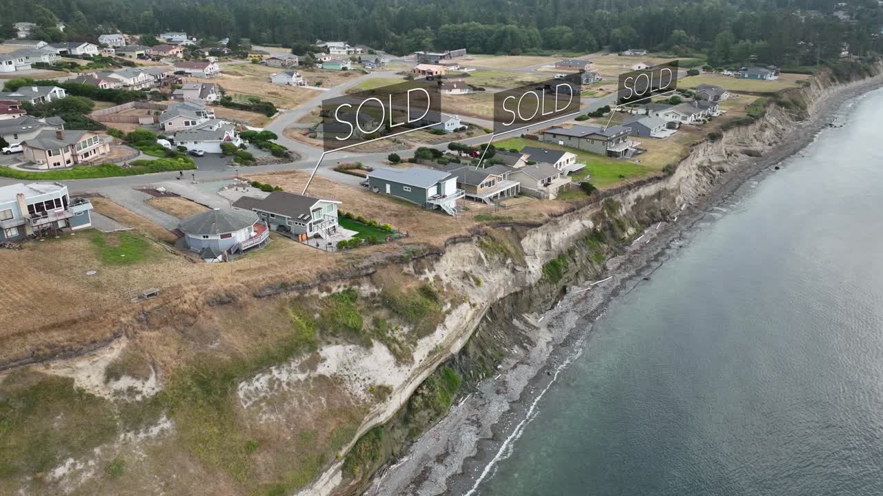 Aerial view of a waterfront neighborhood with &amp;quot;SOLD&amp;quot; signs floating above the fancy homes