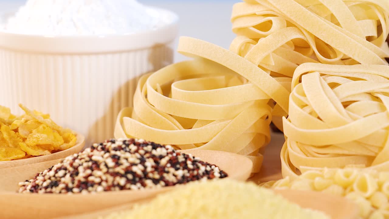 Close-up of various grains and pasta in a well-lit kitchen environment, highlighting textures and colors with a focus on culinary ingredients