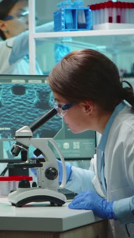 vertical video: microbiologist working late at night for new vaccine