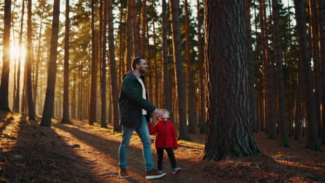 father and son exploring a pine forest at sunset