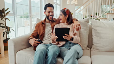 couple relaxing on the couch with a tablet and smartphone