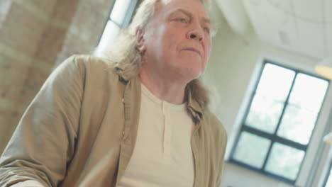 mature musician drumming in rehearsal studio