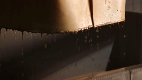 grape juice dripping from chute into collection bin after grape transfer at cellar