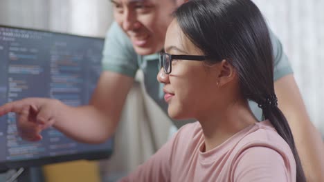 teenage girl learning to code with her father