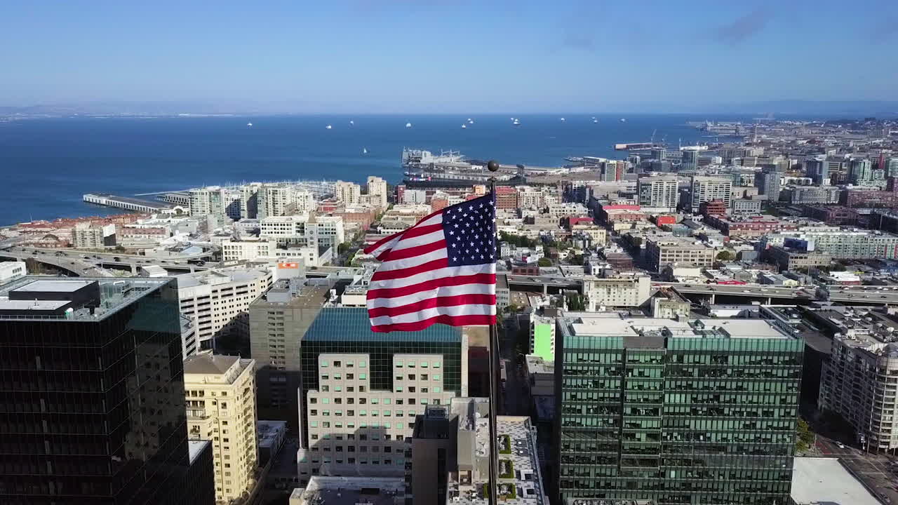 Vista aerea di una bandiera statunitense in cima a un grattacielo, giornata di sole a San Francisco, USA