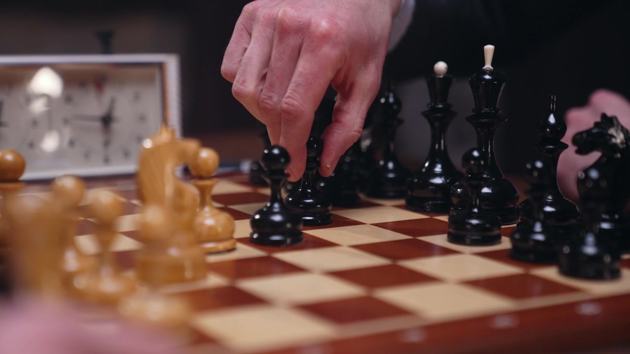Giocatore che sposta un pezzo degli scacchi nero durante una partita
