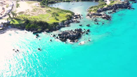 Aerial-view-of-sharp-pointy-rocks-in-turquoise-water-by-tropical-island