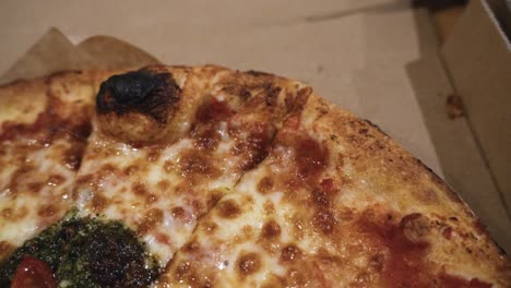 close up shot of delicious italian pizzas delivered in boxes on the wooden table at home, zooming out