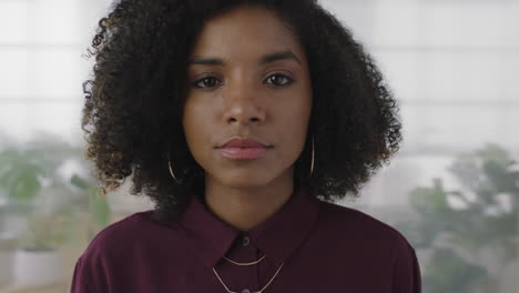 portrait of confident young black business woman intern looking serious at camera independent african american female in office workspace background