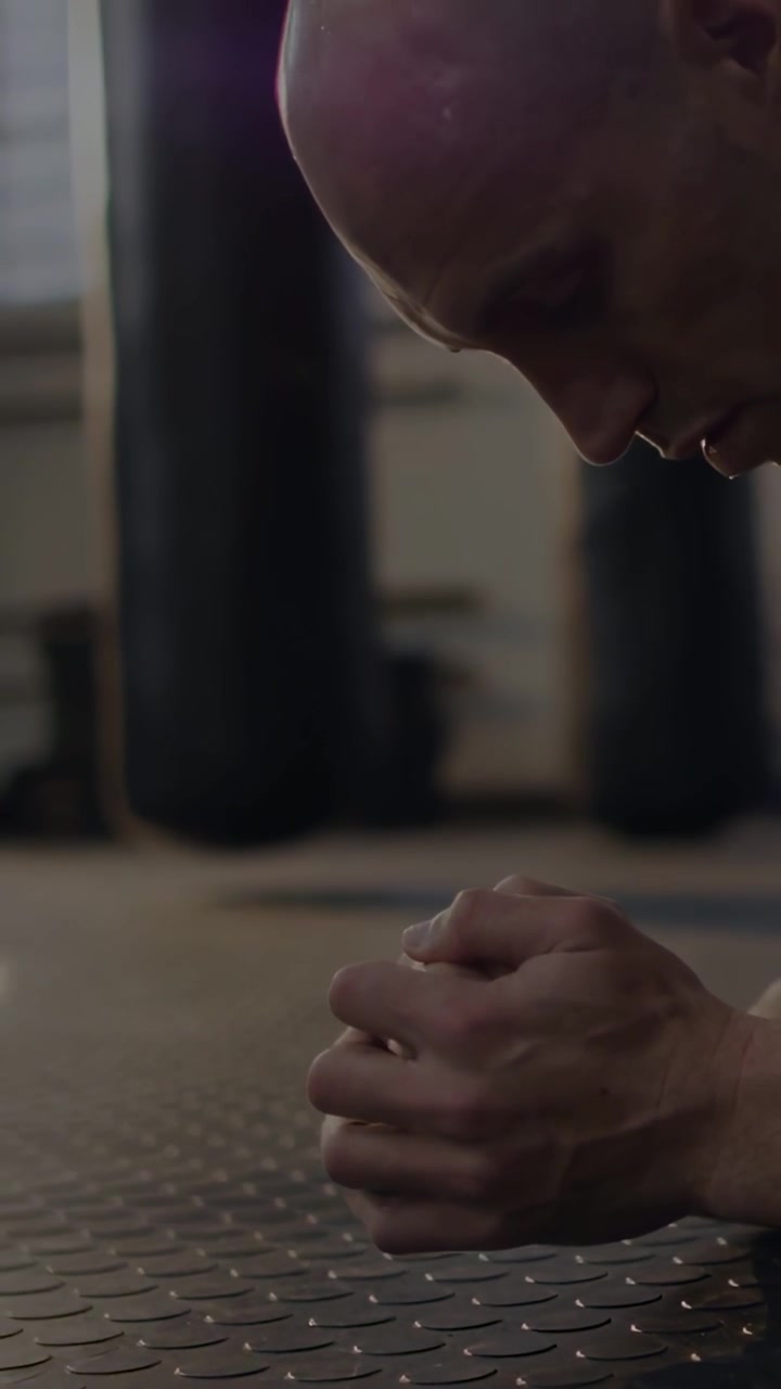 Video verticale: Uomo che inizia un plank sugli avambracci su un tappetino, mantenendo la posizione per il fitness, mentre stelle fluttuano sul tappetino.