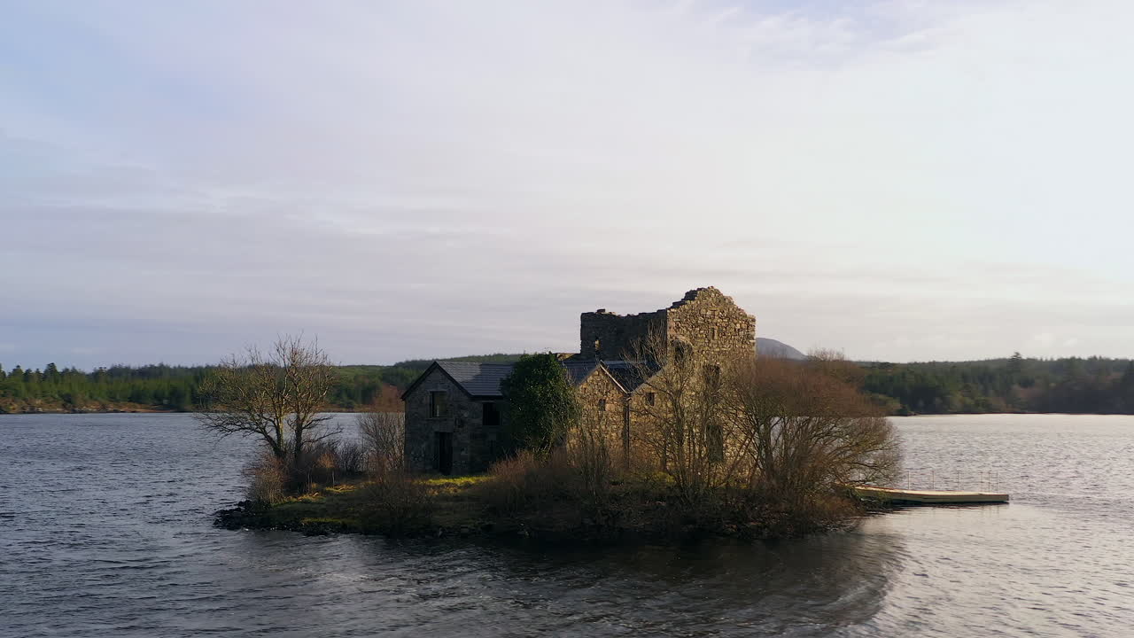 Orbiting shot of O'Flaherty Tower House gliding low over Ballynahinch Lake, Connemara.