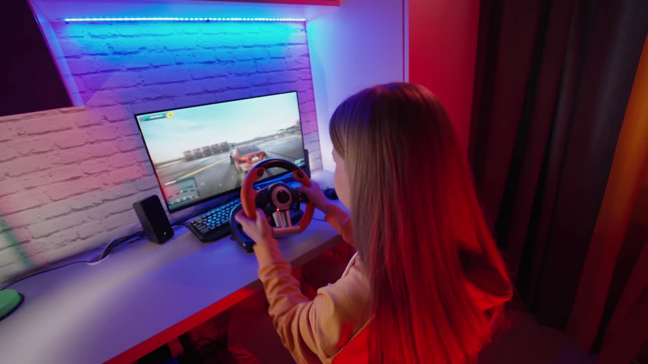 Adolescente che gioca a un videogioco di corse. Ragazza che gioca a un videogioco con volante da corsa a casa.