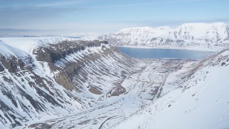 majestuoso valle nevado con lago helado en el horizonte en svalbard, vista aérea