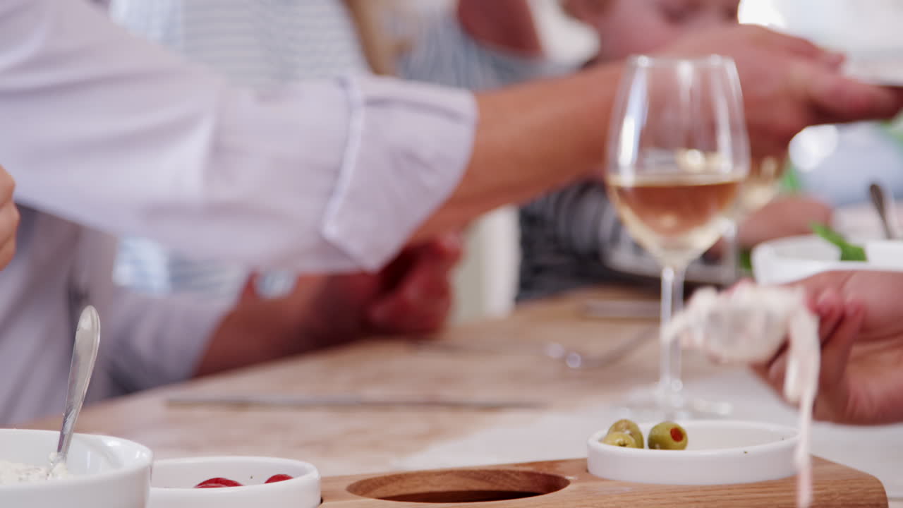 abuelos con nietos sentados alrededor de la mesa y sirviendo comida en la comida familiar