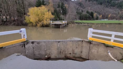 A-shot-of-a-bridge-and-asphalt-road-completely-washed-away-due-to-the-flash-floods-and-heavy-rains-caused-by-the-Pineapple-Express-experienced-in-Abbotsford,-British-Columbia,-Canada