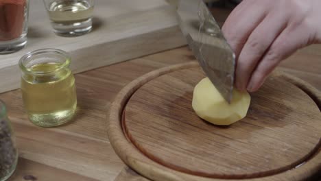 el chef corta las patatas crudas en rebanadas.