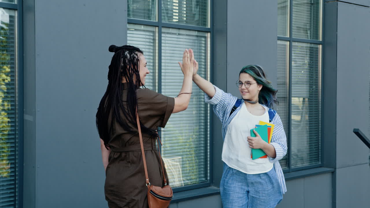 amigos dando la palma fuera de un edificio.