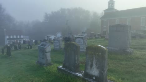 Eerie-parallax-of-red-church-and-old-grave-in-foggy,-scary-conditions
